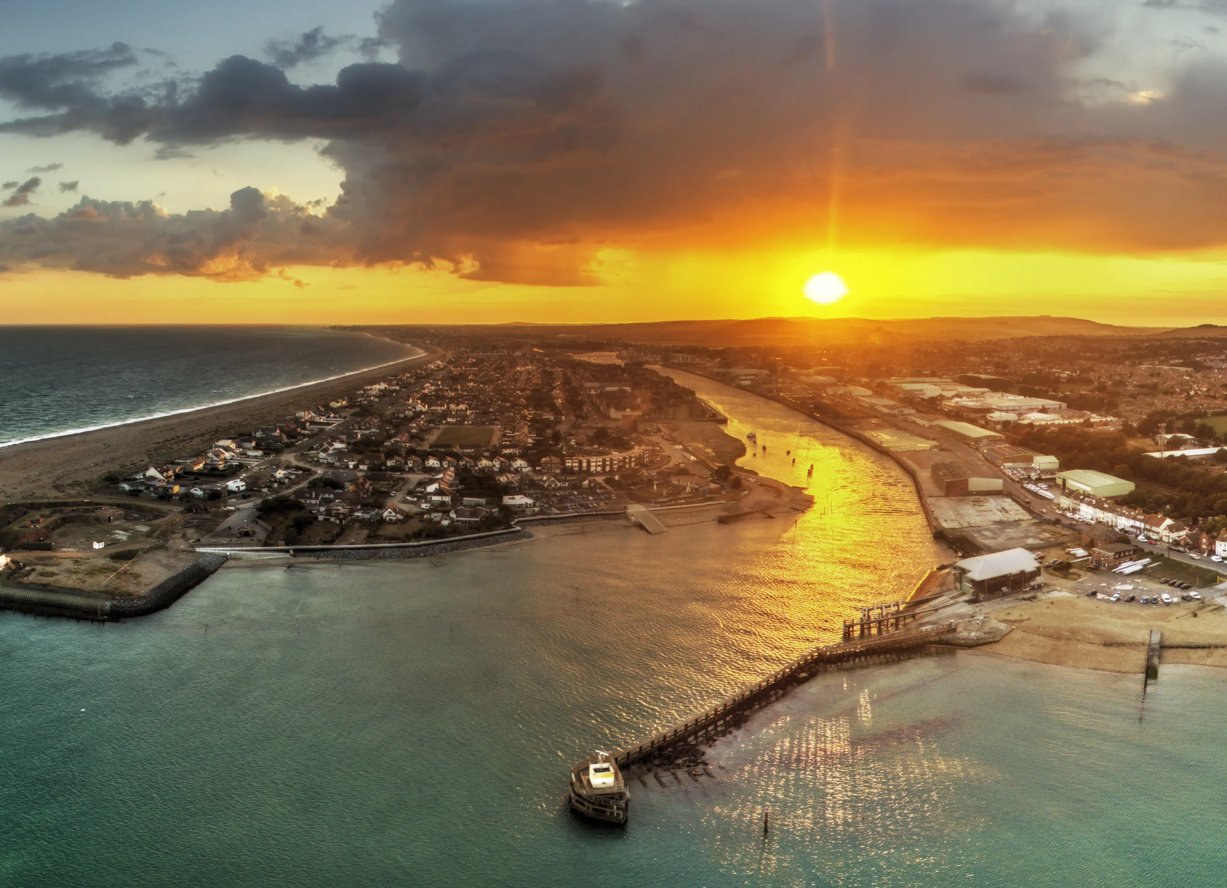 Golden sunset over Shoreham Beach and the harbour arm, seen from the air